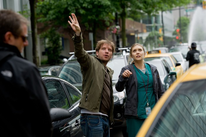   Copyright: © 2014 WARNER BROS. ENTERTAINMENT INC. & LEGENDARY PICTURES PRODUCTIONS LLC  Photo Credit: Kimberley French  Caption: (L-r) Director GARETH EDWARDS and ELIZABETH OLSEN on the set of Warner Bros. Pictures' and Legendary Pictures' epic action adventure "GODZILLA," a Warner Bros. Pictures release.